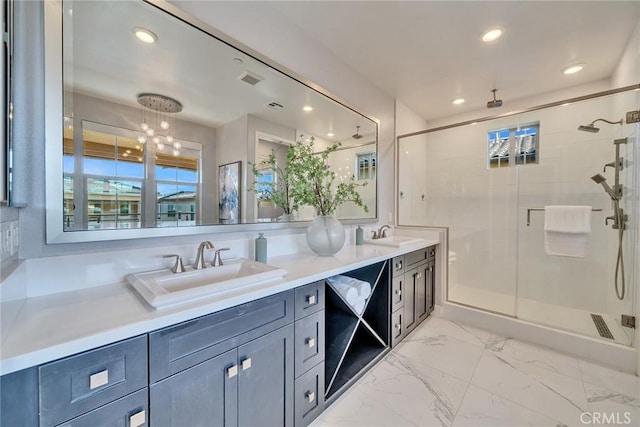 bathroom with a shower with door and vanity