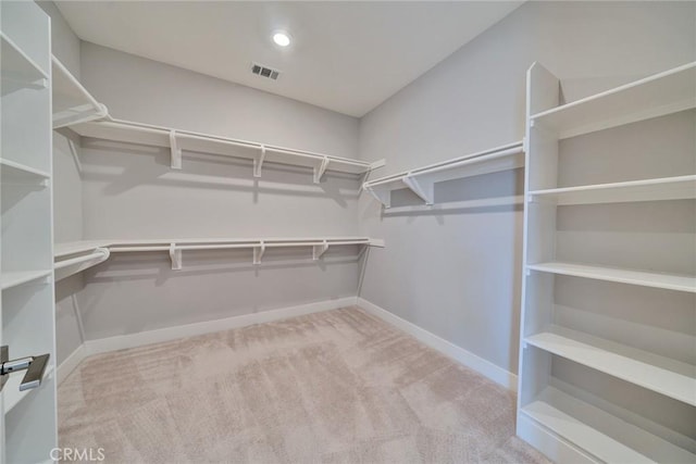 walk in closet featuring light colored carpet