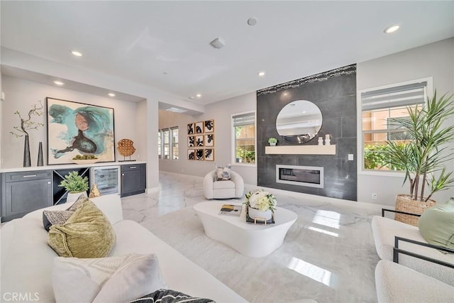 living room featuring a wealth of natural light, wine cooler, and a fireplace