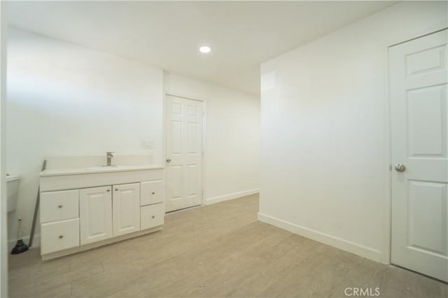 bathroom featuring wood-type flooring, toilet, and vanity