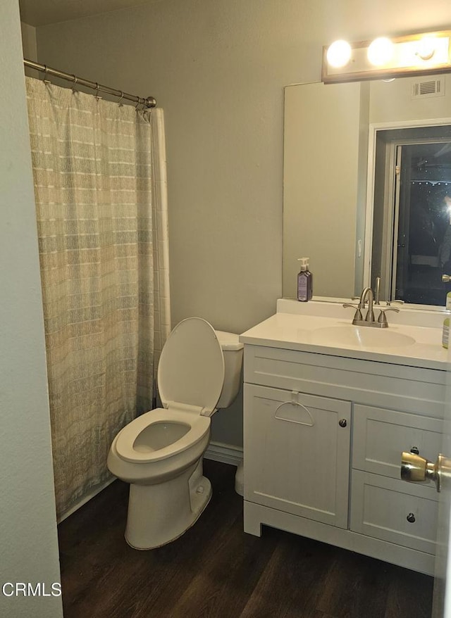 bathroom featuring a shower with curtain, hardwood / wood-style flooring, toilet, and vanity