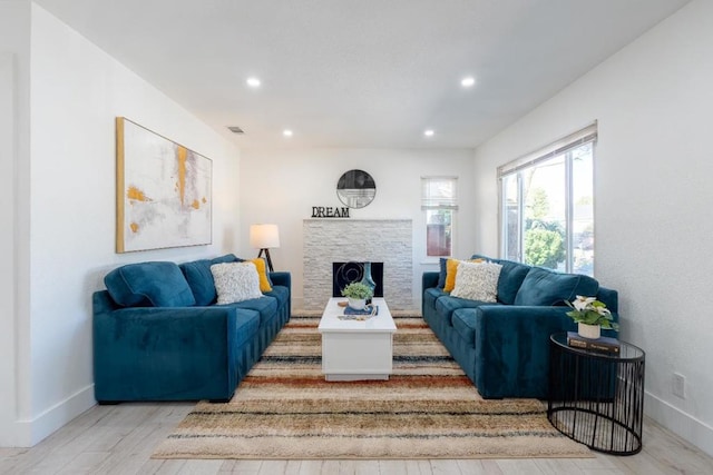 living room with a fireplace and light hardwood / wood-style flooring