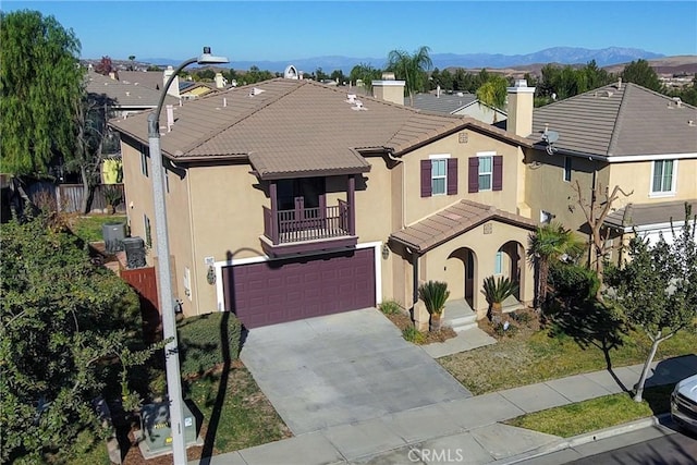 view of front of house featuring a balcony, a garage, and a mountain view