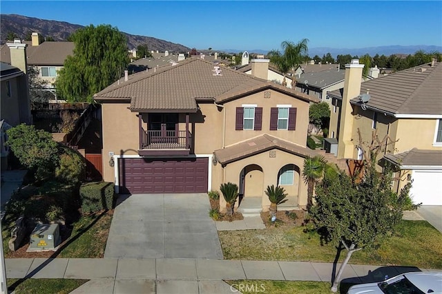 view of front of house with a balcony, a garage, and a mountain view