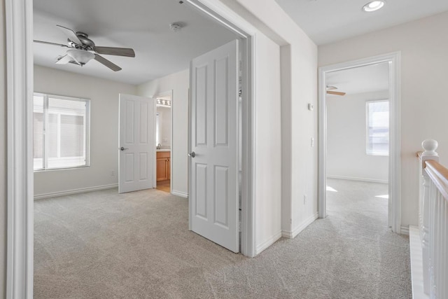 hallway featuring light colored carpet