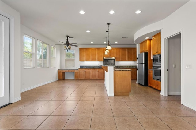 kitchen with light tile patterned flooring, a kitchen island, appliances with stainless steel finishes, hanging light fixtures, and ceiling fan