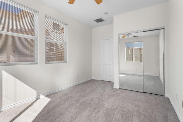 unfurnished bedroom with light carpet, a closet, and ceiling fan