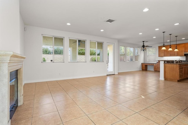 unfurnished living room featuring ceiling fan and light tile patterned floors