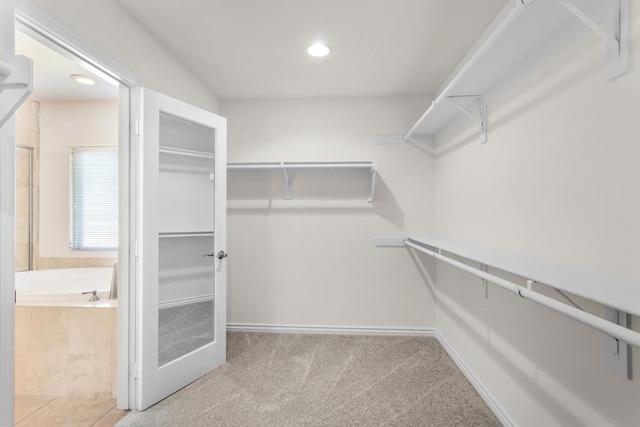 walk in closet featuring light carpet