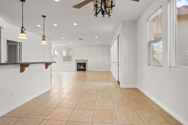 unfurnished living room featuring ceiling fan and light tile patterned floors