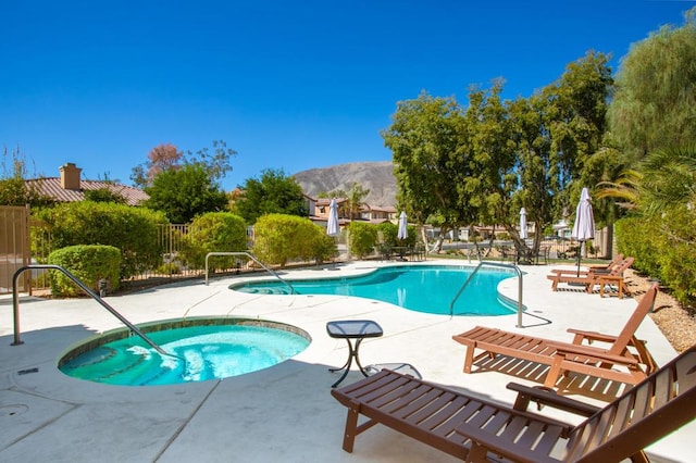 view of pool featuring a mountain view, a community hot tub, and a patio area