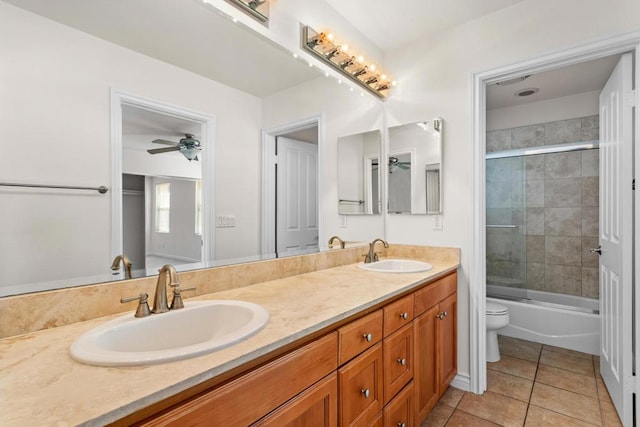 full bathroom with shower / bath combination with glass door, ceiling fan, tile patterned flooring, vanity, and toilet