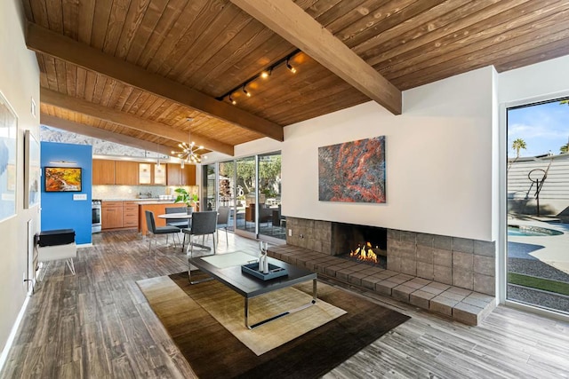 living room featuring a tile fireplace, light hardwood / wood-style floors, lofted ceiling with beams, wood ceiling, and rail lighting