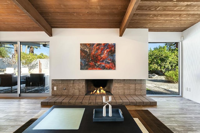 interior space featuring hardwood / wood-style flooring, wooden ceiling, a tile fireplace, and plenty of natural light