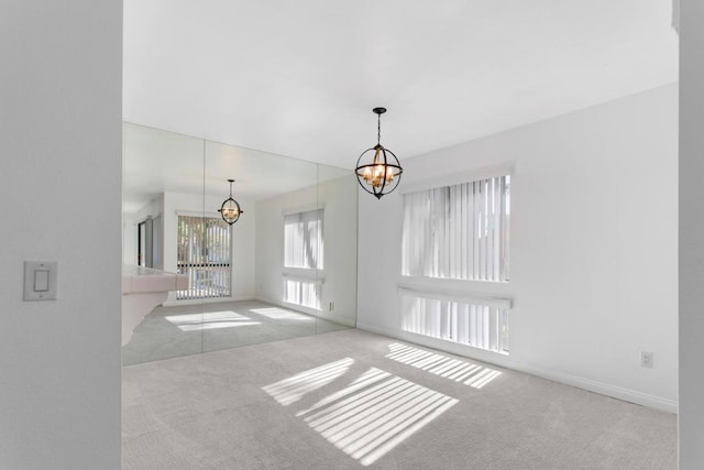 empty room with light carpet and a chandelier