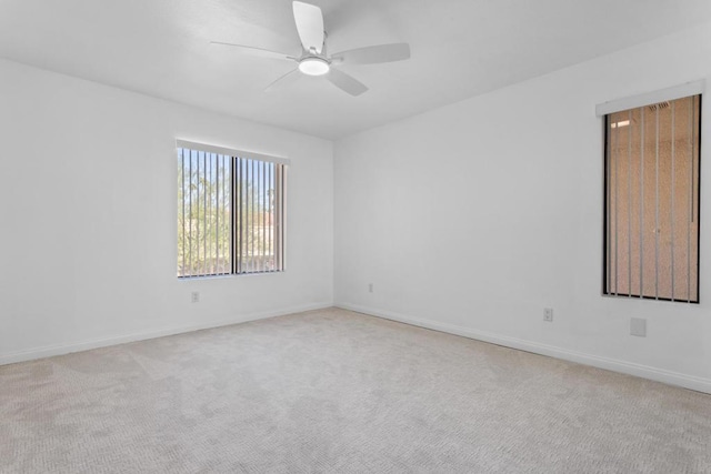 spare room featuring light colored carpet and ceiling fan