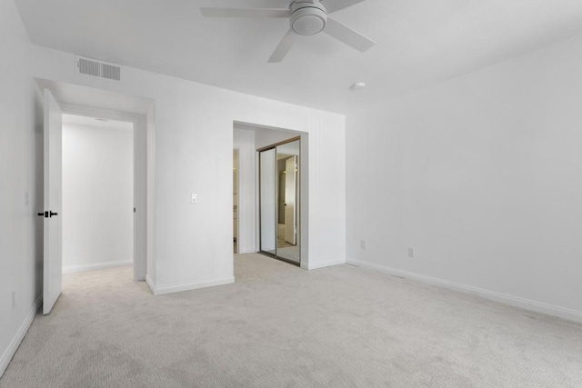 unfurnished bedroom with light colored carpet, a closet, and ceiling fan