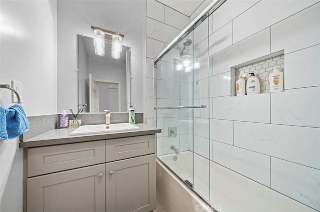 bathroom featuring bath / shower combo with glass door and vanity