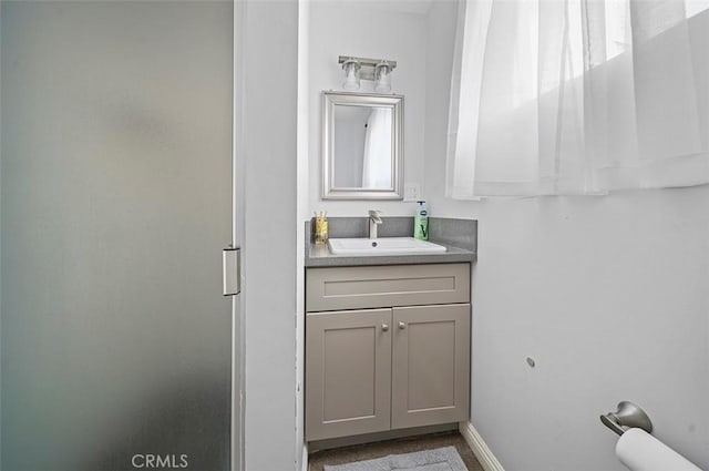 bathroom featuring walk in shower and vanity