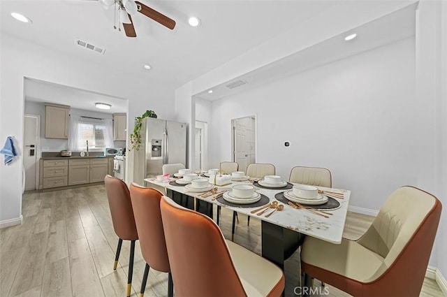 dining area with ceiling fan, sink, and light hardwood / wood-style flooring