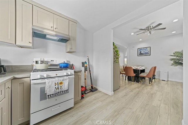 kitchen featuring ceiling fan, gas range gas stove, and light hardwood / wood-style flooring