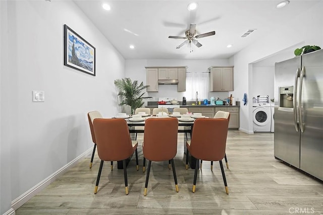 dining room with ceiling fan, sink, washer / dryer, and light wood-type flooring