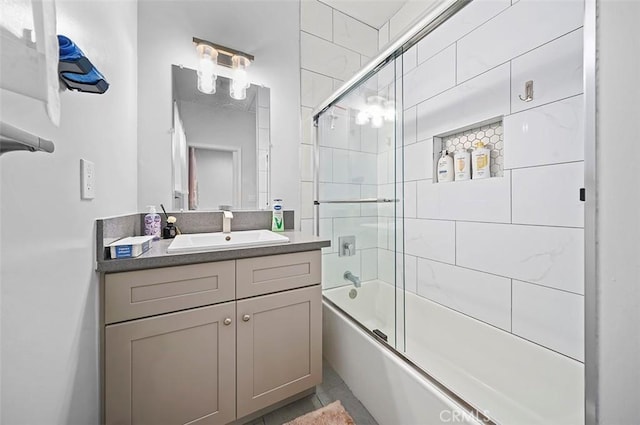 bathroom with tile patterned floors, shower / bath combination with glass door, and vanity