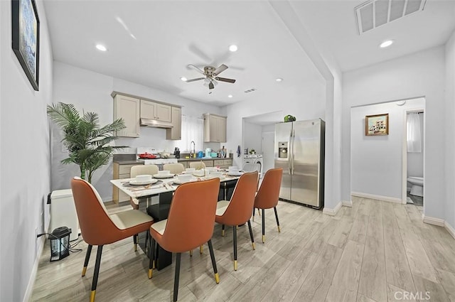 dining space with ceiling fan, sink, and light hardwood / wood-style flooring