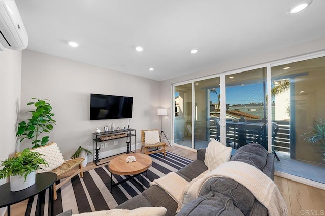 living room with an AC wall unit and light wood-type flooring