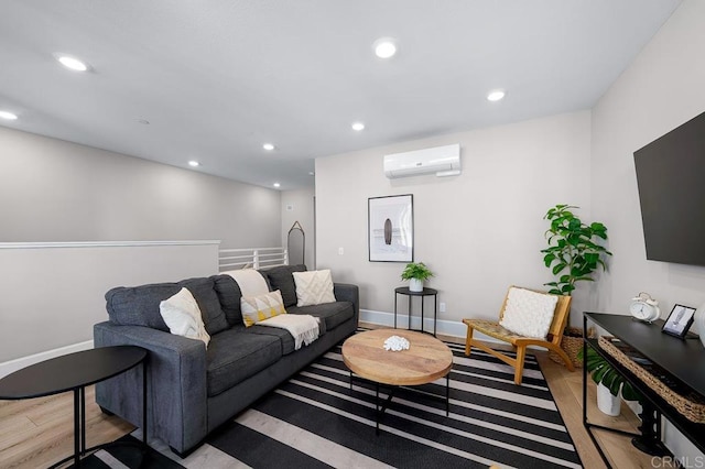 living room featuring a wall unit AC and light hardwood / wood-style floors