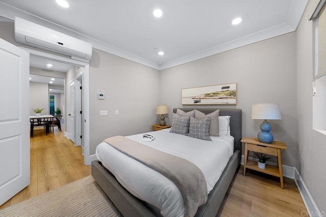 bedroom featuring an AC wall unit, hardwood / wood-style floors, and crown molding