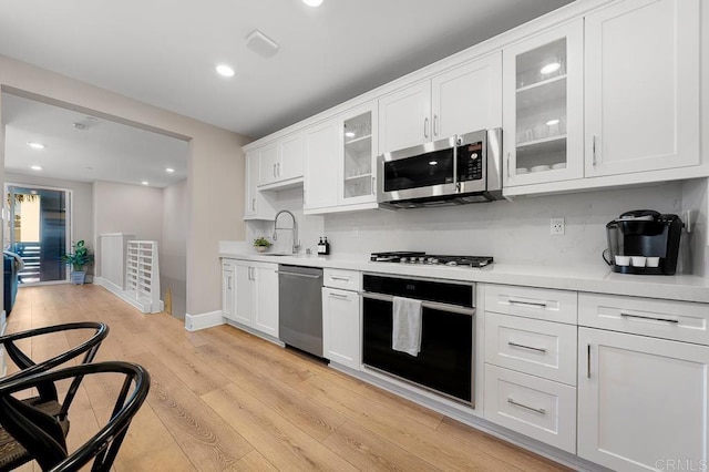 kitchen featuring light hardwood / wood-style floors, sink, white cabinetry, and stainless steel appliances