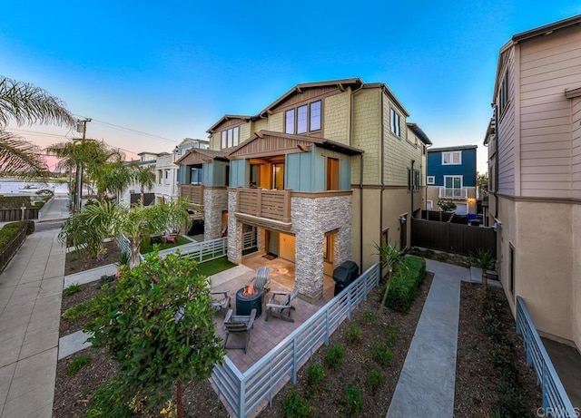 back house at dusk with a patio and a fire pit