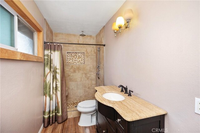 bathroom with walk in shower, vanity, toilet, and hardwood / wood-style flooring