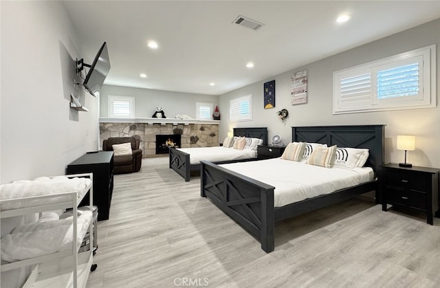 bedroom featuring light hardwood / wood-style floors and a fireplace