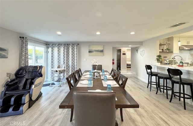 dining room with light hardwood / wood-style floors and sink