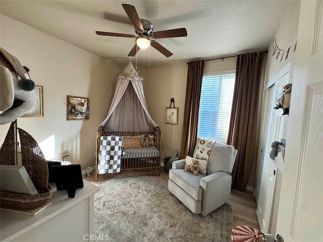 sitting room with a textured ceiling, ceiling fan, and light hardwood / wood-style flooring