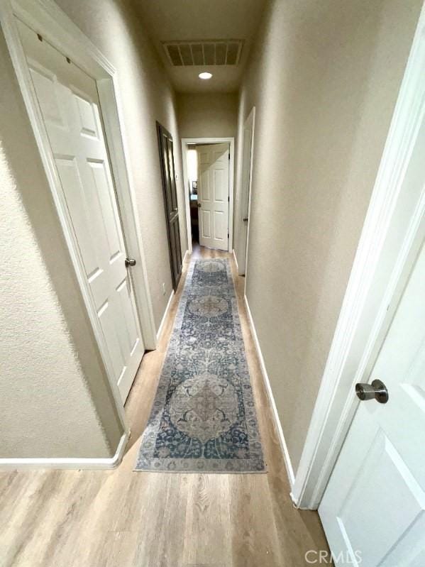 corridor with hardwood / wood-style floors