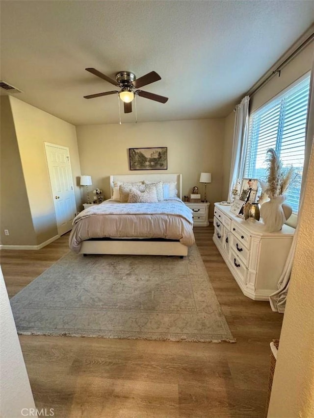 bedroom featuring ceiling fan, a closet, and hardwood / wood-style flooring