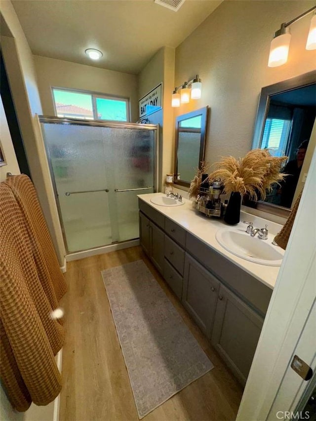 bathroom with vanity, wood-type flooring, and a shower with door