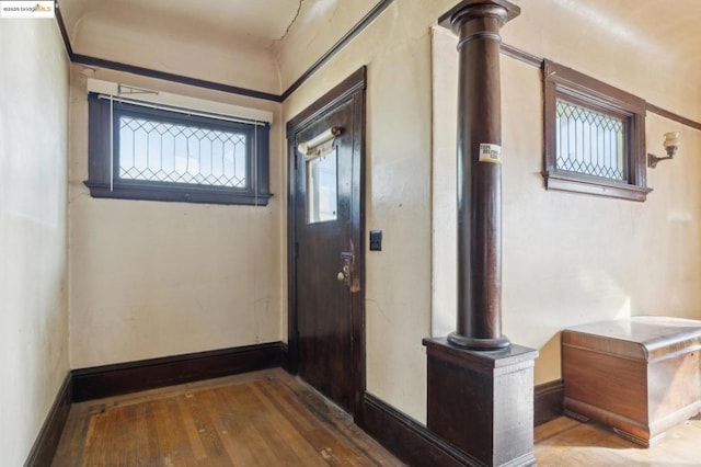 entryway with hardwood / wood-style floors and ornate columns