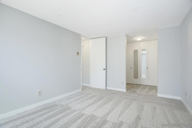 unfurnished room featuring light carpet