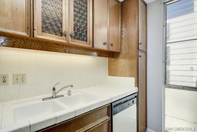 kitchen with tasteful backsplash, sink, and white dishwasher