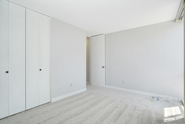 unfurnished bedroom with a closet and light colored carpet