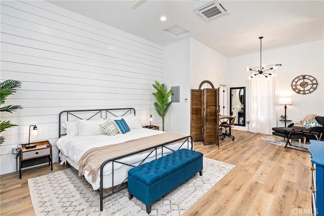 bedroom with light wood-style floors, recessed lighting, visible vents, and an inviting chandelier