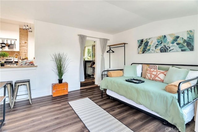 bedroom featuring vaulted ceiling, wood finished floors, and baseboards