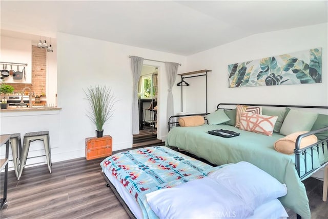 bedroom with lofted ceiling, baseboards, and wood finished floors