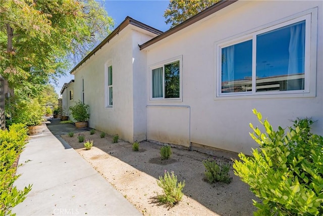 view of side of property with a patio area and stucco siding