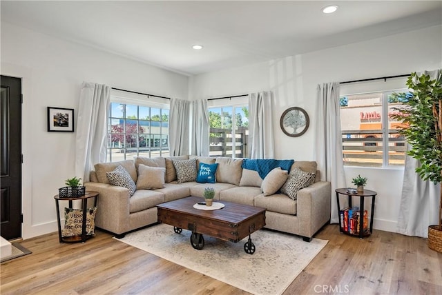 living room with baseboards, light wood finished floors, and recessed lighting