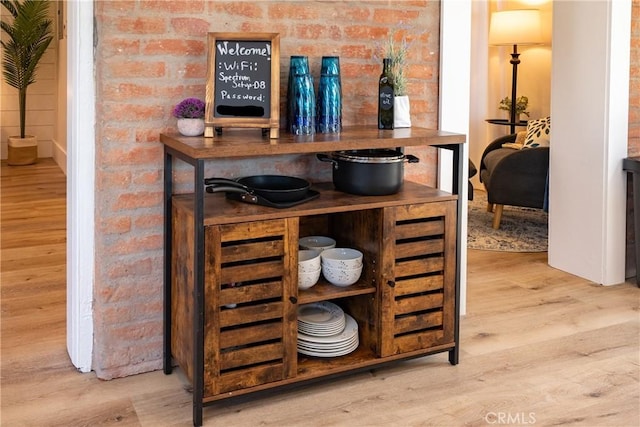 bar with brick wall and wood finished floors